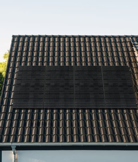 Ein Bild von einem Haus, das eine Solaranlage auf dem Dach hat.